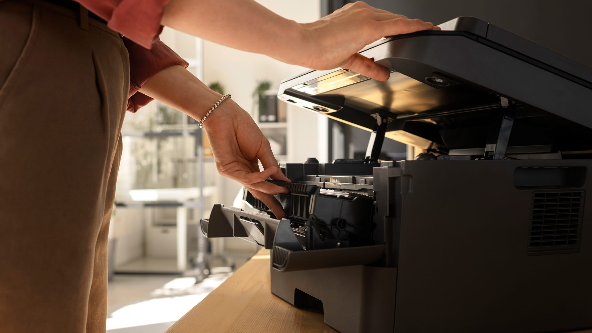 Funcionário resolvendo papel preso na impressora com suporte técnico CenterMaq