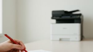Executivo revisando cláusula por cláusula de um contrato de locação de impressoras sobre a mesa, com impressora multifuncional de escritório genérica desfocada ao fundo