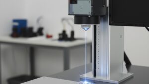 Gravadora a laser realizando gravação a laser para rastreabilidade industrial, marcando um código Data Matrix diretamente na superfície de uma peça metálica industrial sobre bancada
